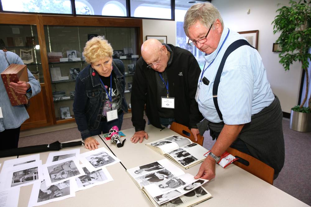 Class of 1968 looking at photos from when they were in school.